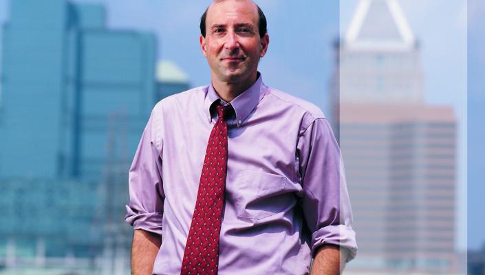 Peter Beilenson with Baltimore's Inner Harbor behind him