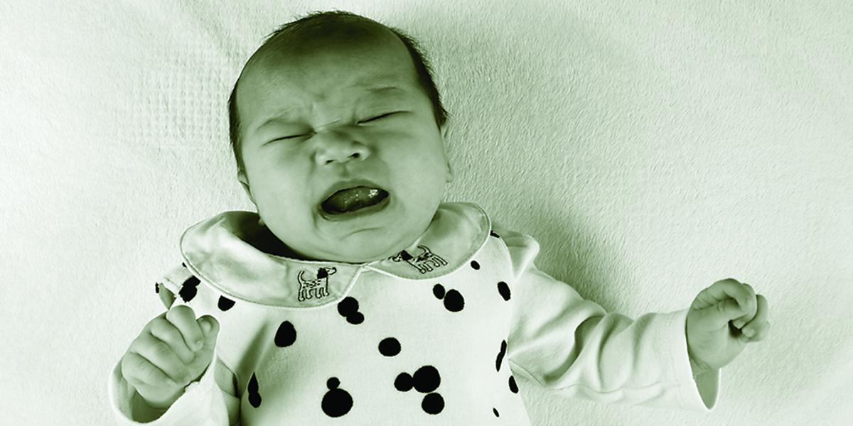 a crying infant lying on his back