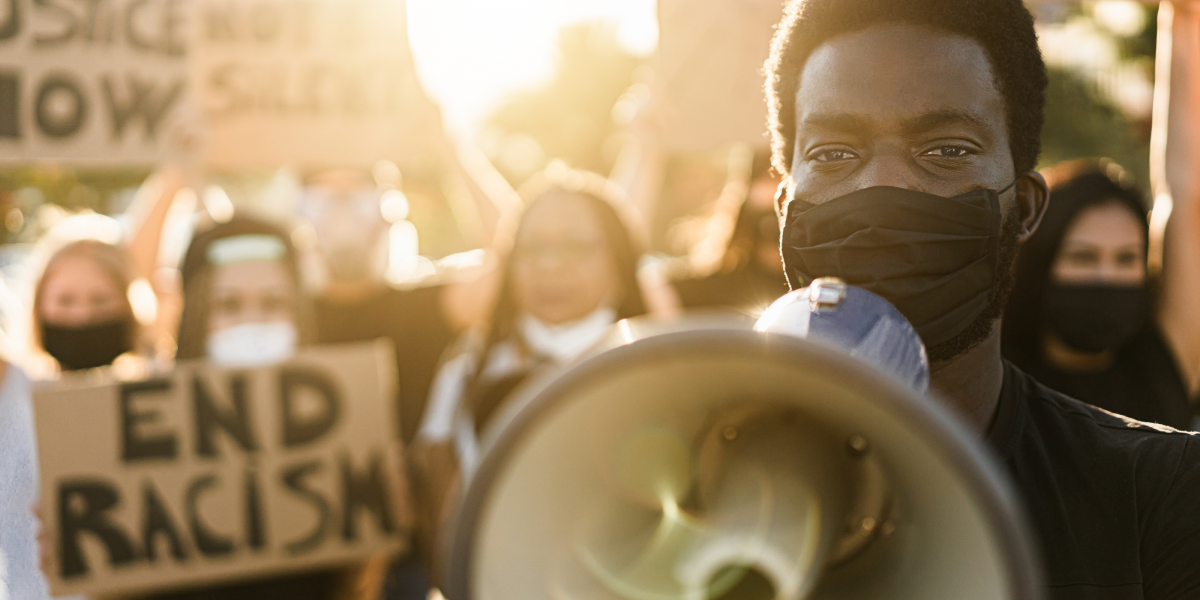 protesters with megaphone and end racism signs