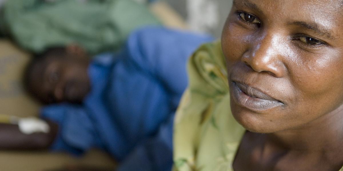 A Ugandan woman sits with a patient at a clinic run by the Rakai Health Sciences Program