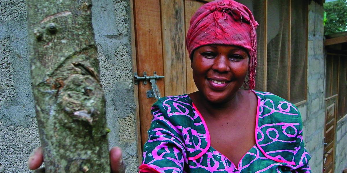 A Tanzanian woman in a colorful pink headscarf and blue and pink dress