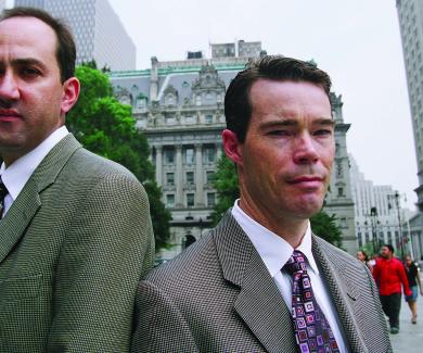 Jon Vernick and Daniel Webster stand back to back on a Baltimore street