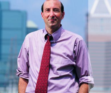 Peter Beilenson with Baltimore's Inner Harbor behind him