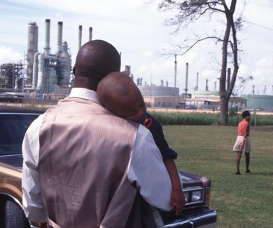 A family leaving church services surrounded by chemical plants