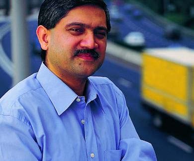 Adnan Hyder stands on a bridge with a highway behind him