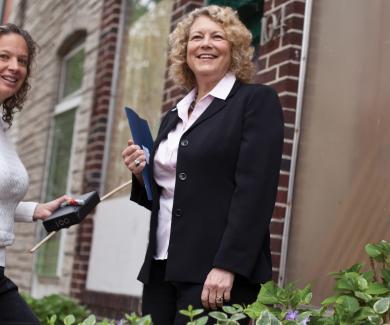 Wendy Shields and Andrea Gielen stand at the entrance to a rowhome in Baltimore