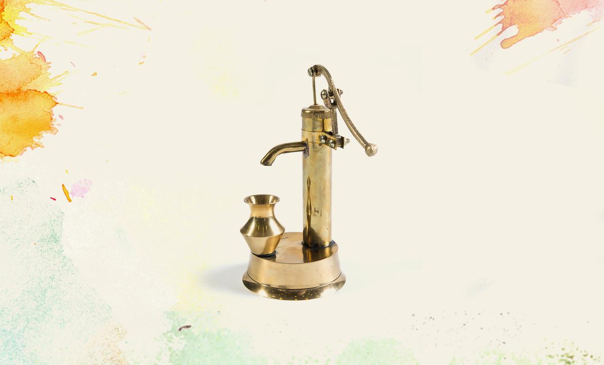 a brass hand pump with water vessel